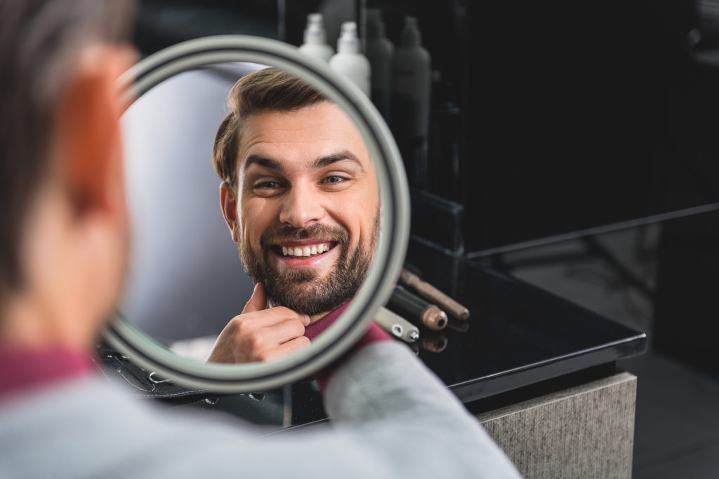 iStock 640272110 1024x683 - Happy man likes his hairstyle -